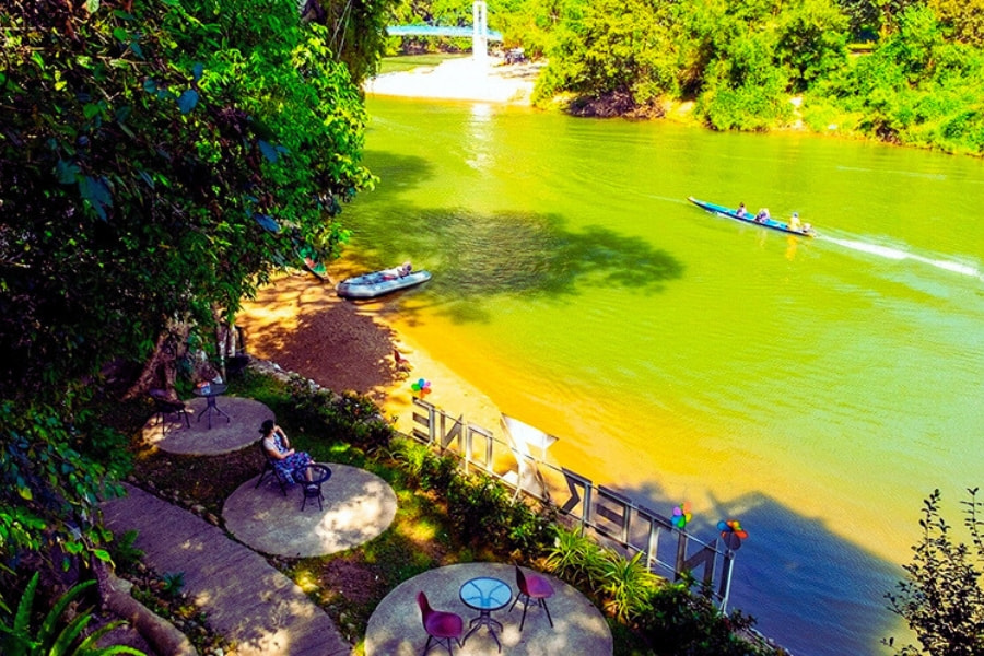 Relaxing riverside view in Vang Vieng with boat on the Nam Song River Laos